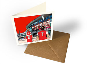 Square Arsenal birthday card with Ella on Mama’s shoulders and Papa, beside its kraft envelope.