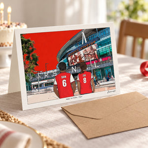 Arsenal birthday card with Dan and Zoe, shown with its kraft envelope in an AI-assisted table scene.